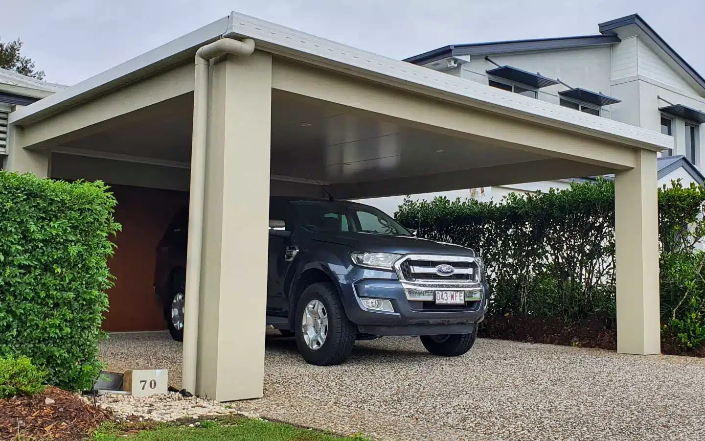 Trueline Pallas insulated carport over a pebblecrete driveway