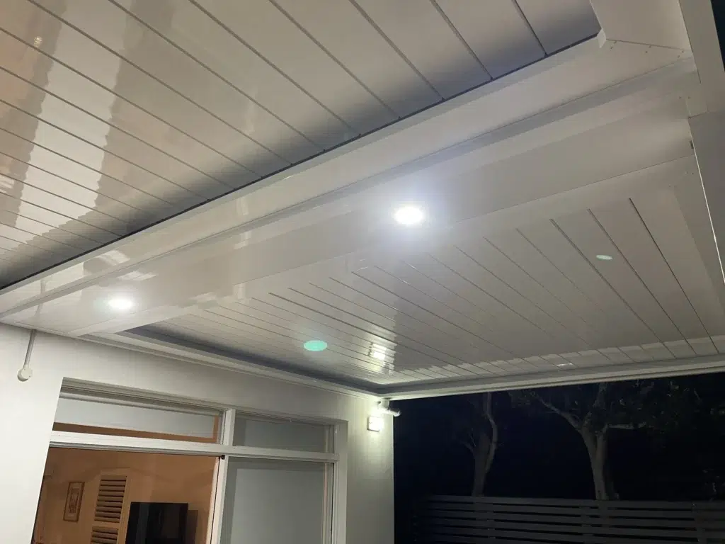 Night-time view of open louvred patio with LED lighting and glass sliding doors to interior, Ascot Queensland