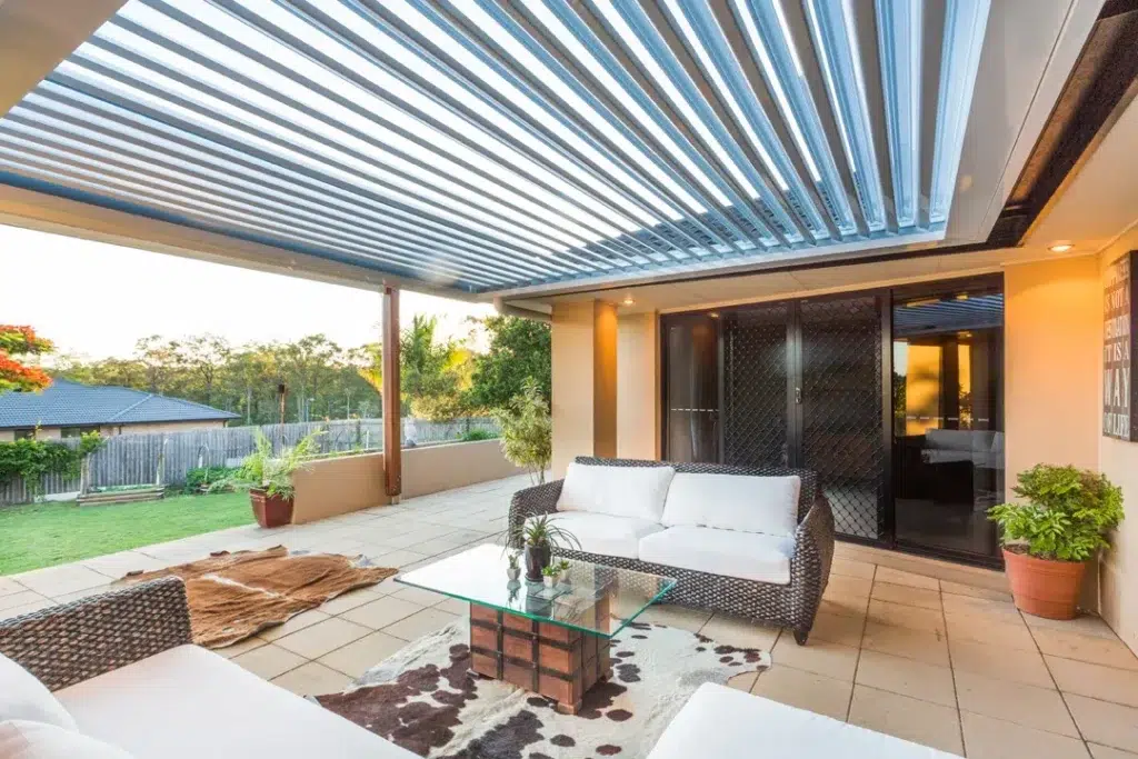 Wide exterior view of insulated louvred patio attached to brick-rendered suburban home with garden steps, Moggill Queensland