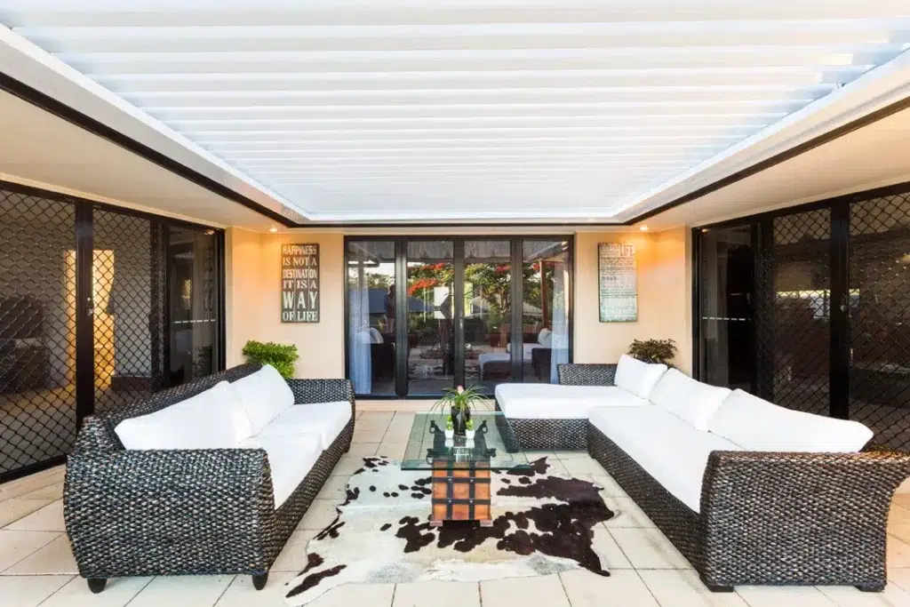 Insulated patio roof with louvred structure attached to cream-rendered home with garden steps and potted plants, Moggill Queensland