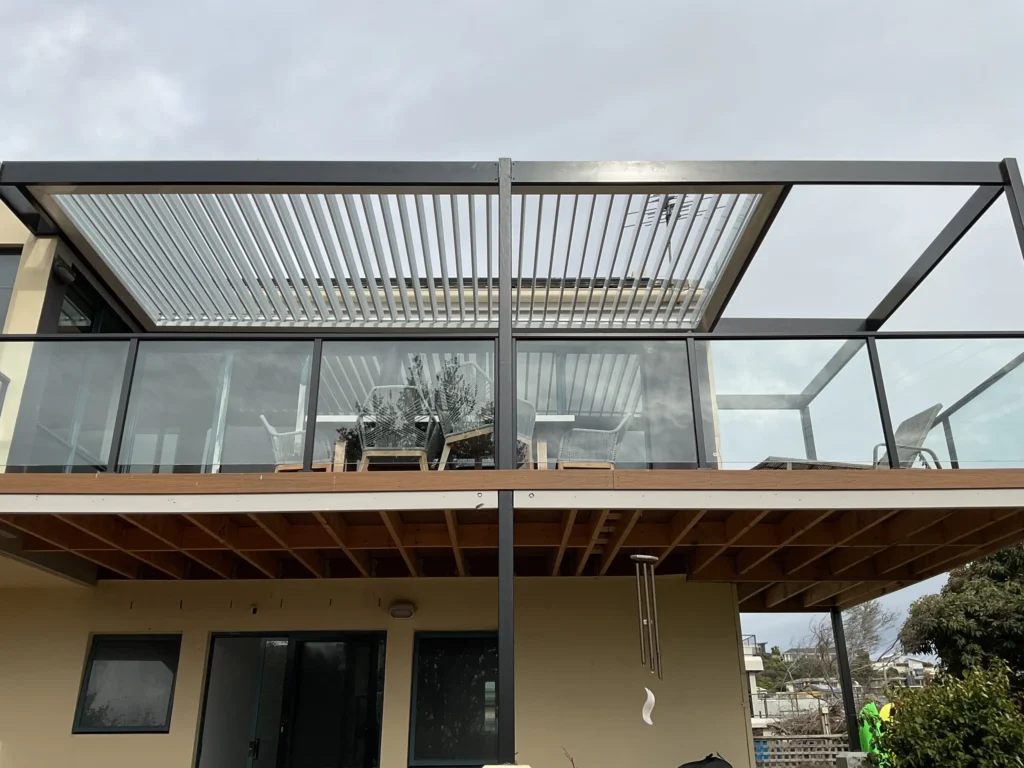 Louvred pergola with open louvres on second-storey balcony of two-storey coastal home, Frankston Victoria