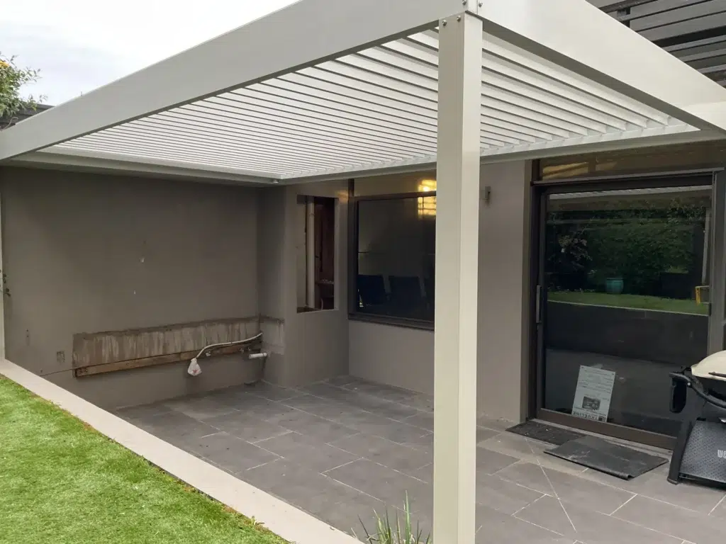 Underside view of white louvred pergola with garden plantings and sculptured hedges beyond, Glen Iris Victoria